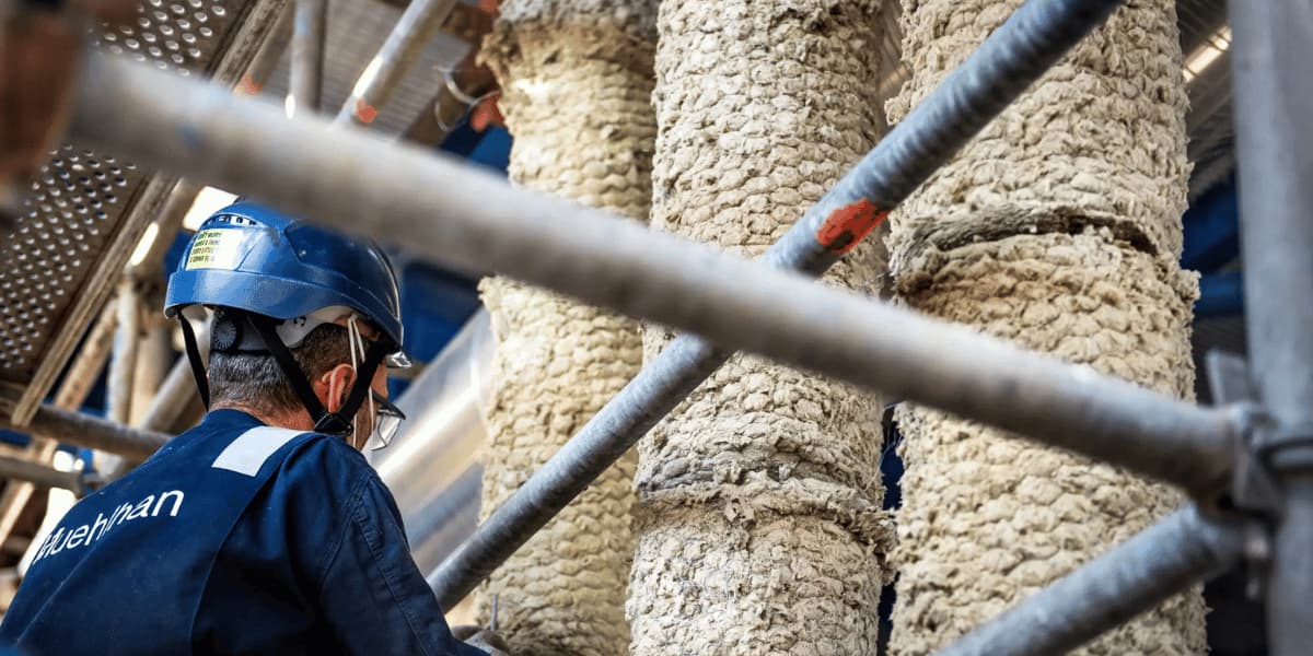 Industrial technician inspecting insulated piping and equipment