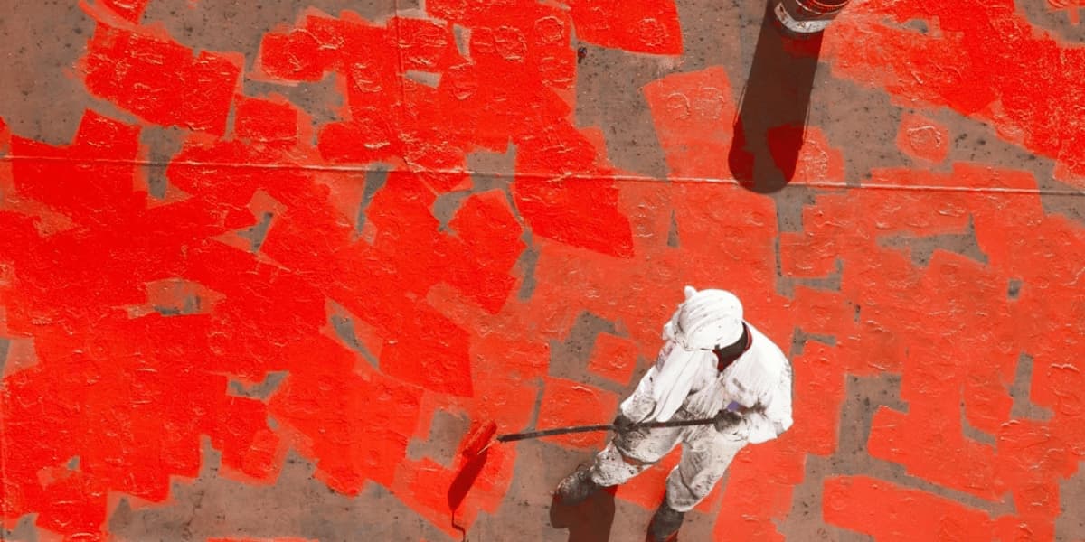 Technician applying protective coating to a marine deck surface