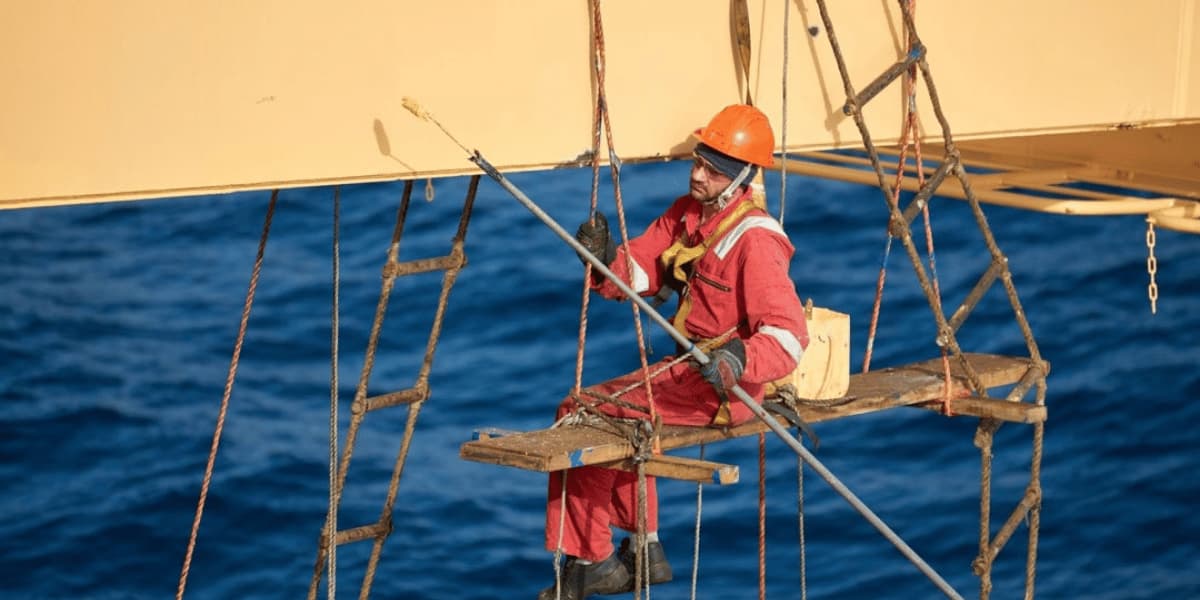 Technician applying protective coating to an offshore marine structure