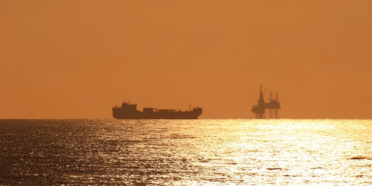 Offshore platform and marine vessel at sunset representing Trussco environmental services